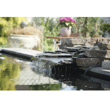 Tuinvijver met waterval van stenen platen in tuin