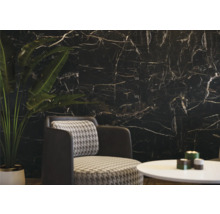 Woonkamer met zwarte marmeren muur, fauteuil en tafel