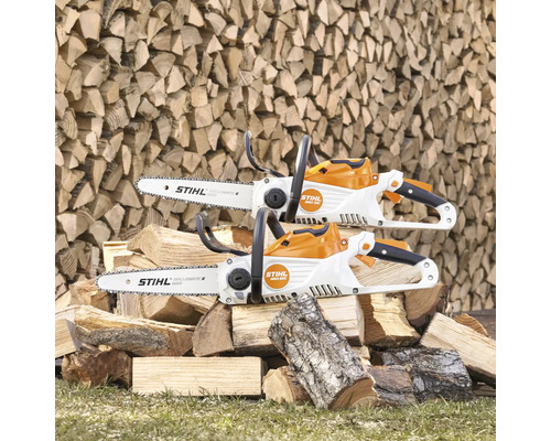 Twee Stihl accukettingzagen op een stapel hout