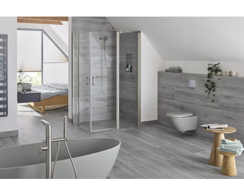 Moderne badkamer met douche, bad, toilet en tegels met houtlook.