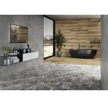 Moderne badkamer met grijze tegels, wastafel, spiegel en vrijstaand bad.