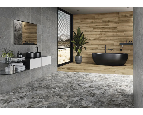 Moderne badkamer met grijze tegels, wastafel, spiegel en vrijstaand bad.