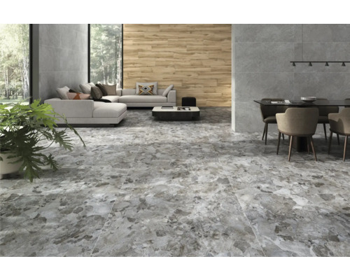 Woonkamer met lichtgrijze vloer in steenlook, bank en eettafel