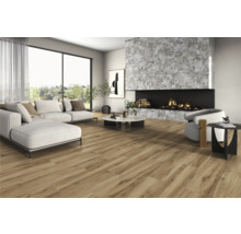 Woonkamer met bank, fauteuil, open haard en houtlook vloertegels voor een lichte, ruime sfeer.