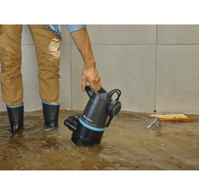 Man met Gardena vuilwaterpomp in overstroomde ruimte.