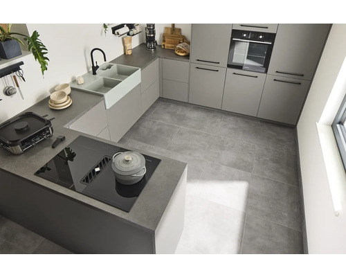 Lichte keuken met inbouwkasten, spoelbak, kookplaat en tegelvloer.