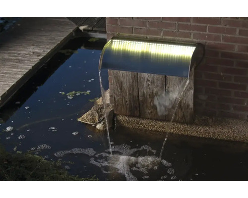 Tuinfontein met waterval en verlichting in een vijver