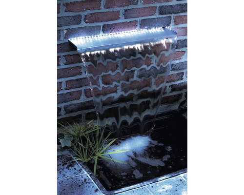 Verlichte waterval voor een bakstenen muur