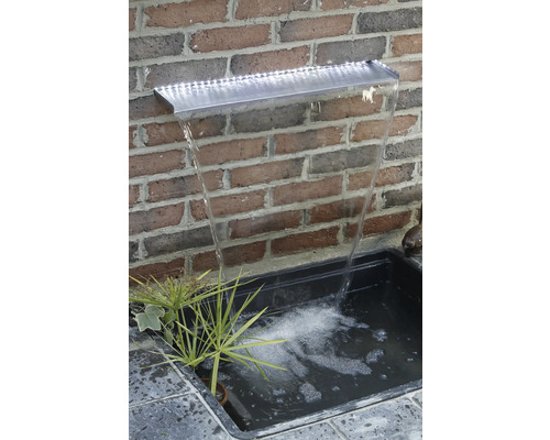 Tuin fontein met LED verlichting en waterval tegen een bakstenen muur