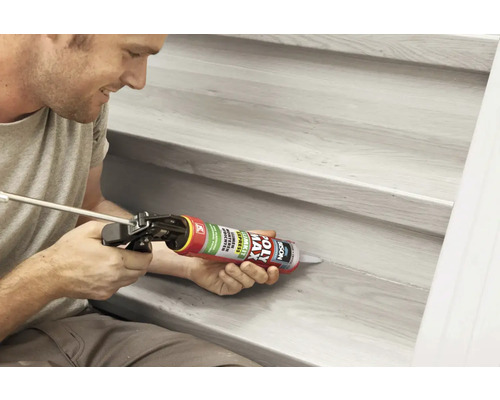 Man dicht trap af met een kitpistool en afdichtmiddel