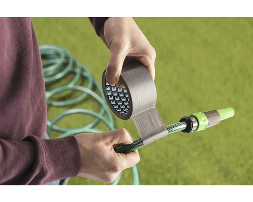 Persoon repareert tuinslang met ducttape.