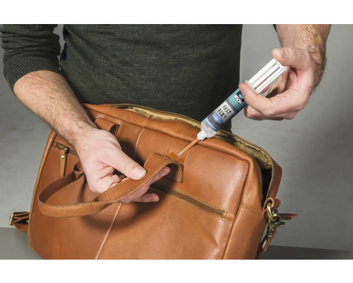 Reparatie van een bruine leren tas met een lijmstift