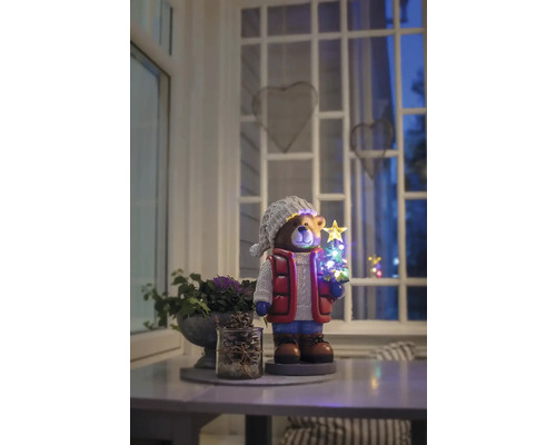 Decoratief berenfiguur met LED-kerstboom op een tafel in een kamer.