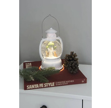 Decoratieve lantaarn met sneeuwbol, engel en kerstboom op een nachtkastje