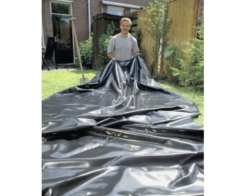 Man houdt vijverfolie vast in de tuin