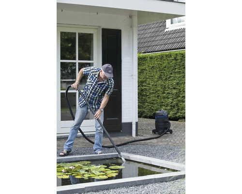 Een persoon maakt een tuinvijver schoon met een vijverstofzuiger.