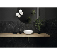 Moderne badkamer met zwart visgraatmotief, wastafel, ronde spiegel en verlichting