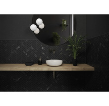 Moderne badkamer met zwarte visgraatmotief tegels, houten wastafel en ronde spiegel