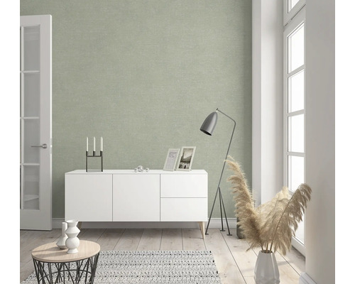 Woonkamer met decoratief wandbehang, wit dressoir en staande lamp.