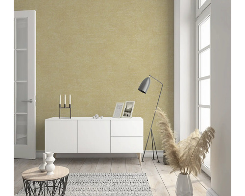 Woonkamer met een gestructureerd behang, een dressoir, een staande lamp en decoratieve elementen.