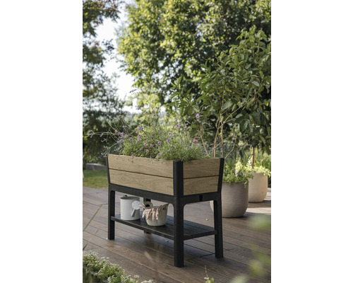 Houten en metalen plantenbak op poten met opbergruimte in de tuin