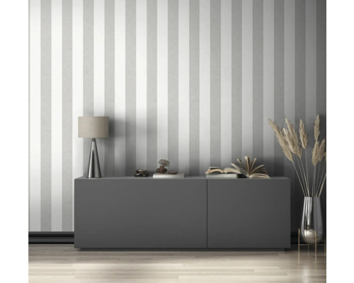 Woonkamer met gestreept behang, dressoir, lamp en decoratie