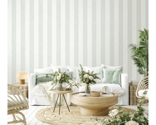 Lichte woonkamer met gestreept behang, bank, tafel en planten voor een vriendelijke sfeer.