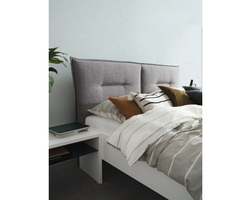 Bed met gestoffeerd hoofdeinde, beddengoed en nachtkastje