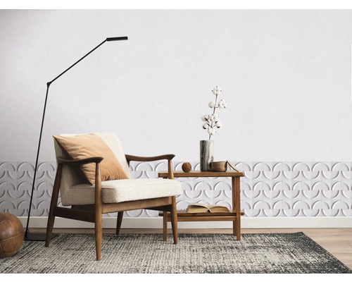 Lichte kamer met fauteuil, vloerlamp en decoratieve wandbekleding