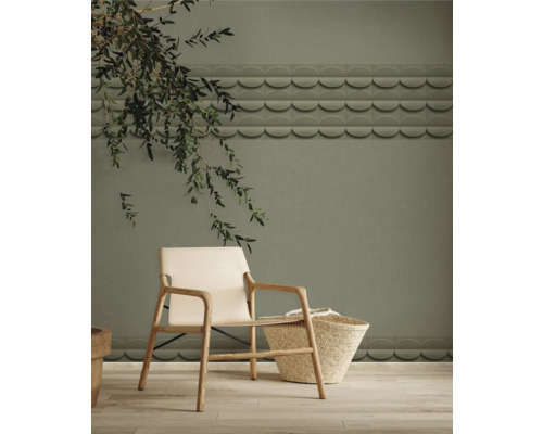 Interieurscène met een stoel, een mand en decoratieve wandtegels in een woonkamer.