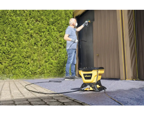 Man schildert garagedeur met verfspuitsysteem van Wagner