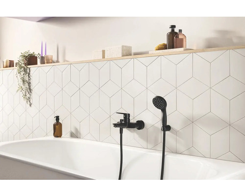 Badkamer met ligbad, kraan en geometrische tegels