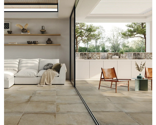 Woonkamer met vloertegels, bank en buitenruimte met zitgelegenheid