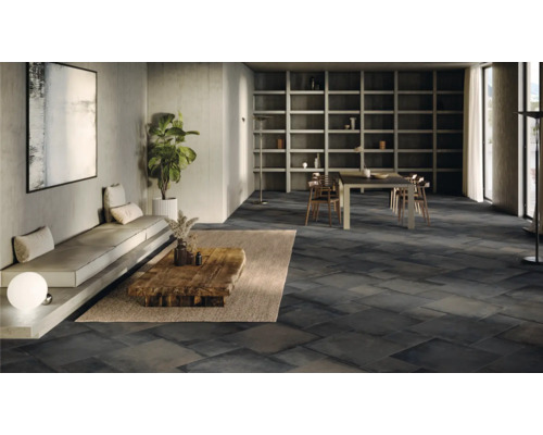 Ruime woonkamer met donkere tegelvloer, zithoek en eettafel