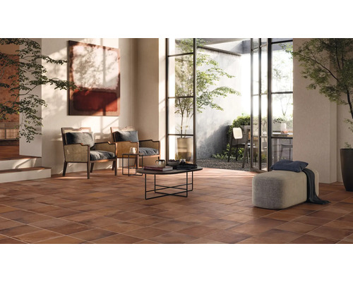 Woonkamer met bruine vloertegels, zitplaatsen en toegang tot buiten.