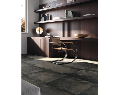 Werkkamer met bureau, stoel en donkere vloertegels.