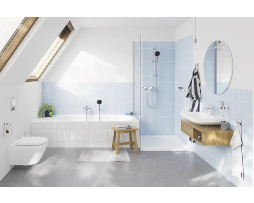 Lichte badkamer met bad, douche, wastafel en dakraam