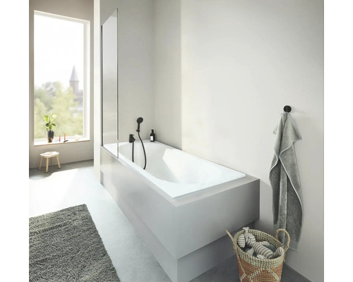 Lichte badkamer met ligbad, douchewand en handdoek