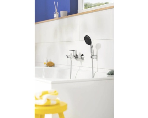 Foto van een badkamer met badkraan en handdouche aan een badkuip