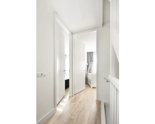 Lichte hal met houten vloer, witte muren en twee open deuren naar slaapkamer en kinderkamer