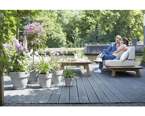 Terras met houten vloer, beplante potten en een stel op een bank