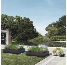 Twee beplante plantenbakken in een tuin met een vijver