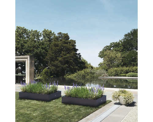 Twee beplante plantenbakken in een tuin met een vijver