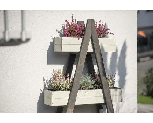 Houten ladderrek met beplante bloembakken tegen een huismuur