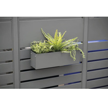 Decoratieve plantenbak met planten aan een privacyscherm