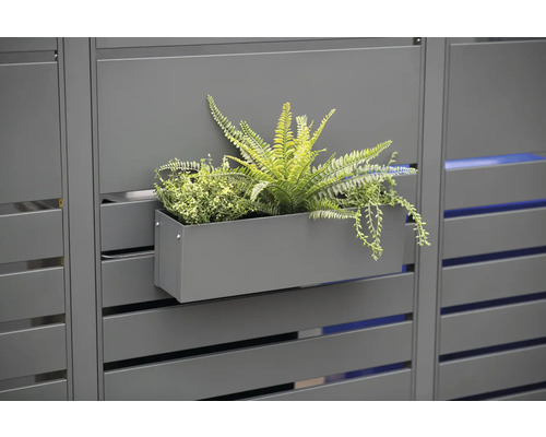 Decoratieve plantenbak met planten aan een privacyscherm