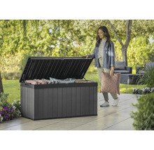 Geopende kunststof tuinkist met kussens en een vrouw in de tuin