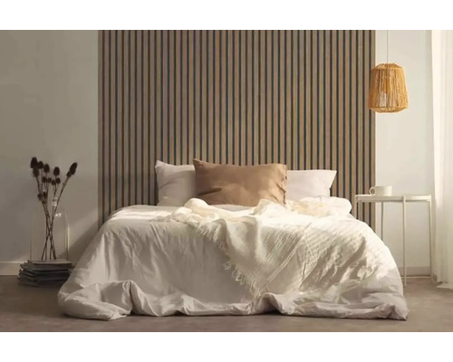 Slaapkamer met bed voor een houten lattenwandbekleding, nachtkastje en lamp