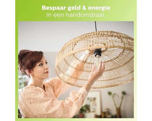 Vrouw vervangt gloeilamp in een lamp met rotan kap