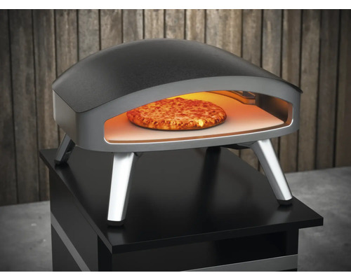 Pizzaoven met pizza erin op een tafel